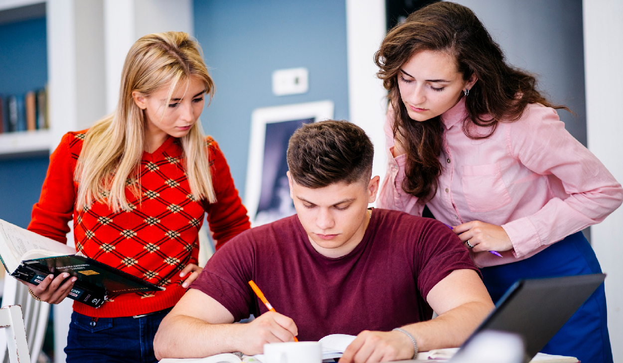 Group of students sitting outside smiling