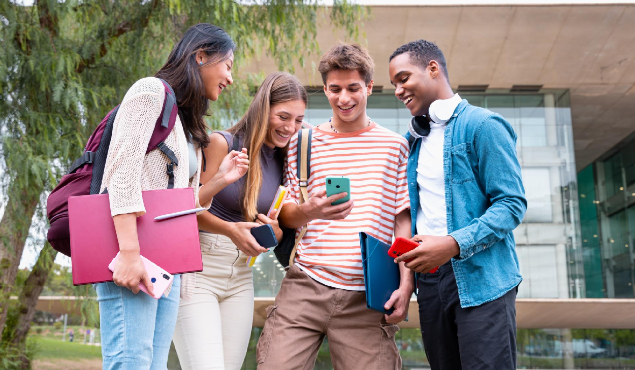 Group of students sitting outside smiling